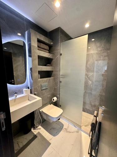 uma casa de banho com um lavatório, um chuveiro e um WC. em Appartement Prestigia 3 chambres em Marraquexe