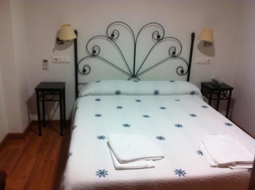 a bedroom with a bed with blue flowers on it at Hotel Mesón del Moro in Abarán