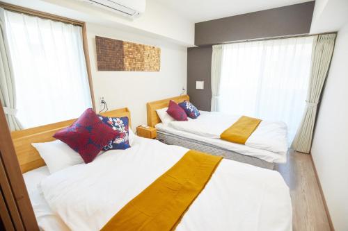 two beds in a room with two windows at SG Premium KASAI - Vacation STAY 44266v in Tokyo