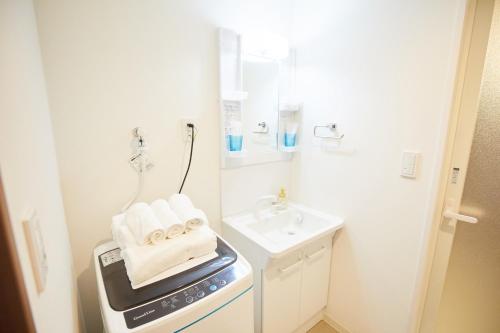una pequeña cocina blanca con fregadero y toallas en SG Premium KASAI - Vacation STAY 44266v, en Tokio