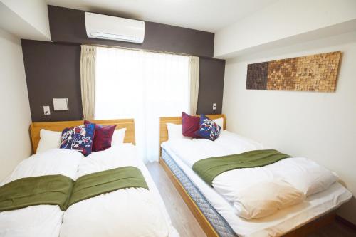 a bedroom with two beds and a window at SG Premium KASAI - Vacation STAY 44284v in Tokyo
