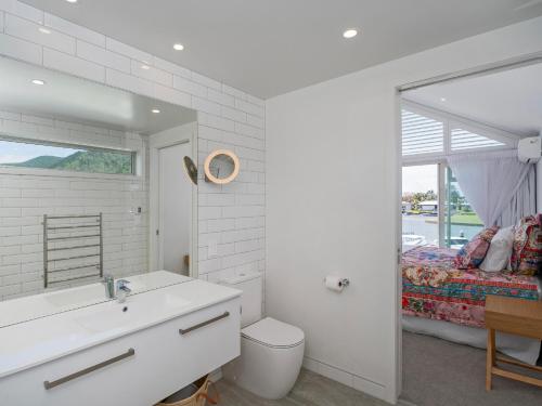 a white bathroom with a sink and a bed at Villa Viti - Pauanui Holiday Home in Pauanui