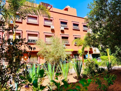 an orange building with plants in front of it at SABOR FAMILY APARTS -Jaouharat Al Atlas in Marrakech