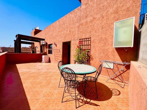 a patio with a table and chairs on a building at SABOR FAMILY APARTS -Jaouharat Al Atlas in Marrakech