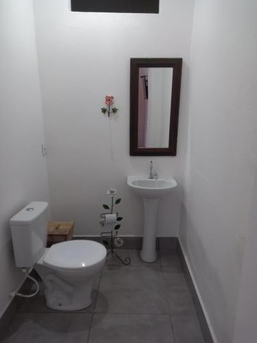 a white bathroom with a toilet and a sink at Pousada Tabernáculo in Tiradentes
