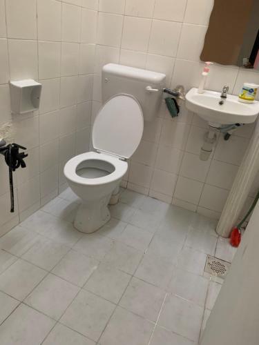 La salle de bains est pourvue de toilettes et d'un lavabo. dans l'établissement Full House Ville Rawang, à Rawang