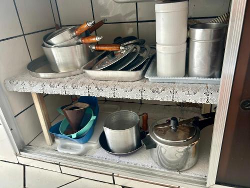 a shelf with pots and pans and other kitchen utensils at Casa em Limeira à 1,7km da Unicamp in Limeira