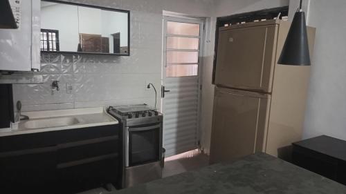 eine kleine Küche mit Spüle und Kühlschrank in der Unterkunft Espaço Casa Branca in Caraguatatuba