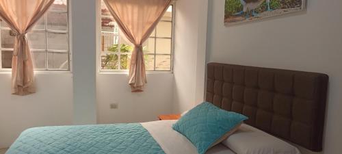 a bedroom with a bed and two windows at Teresita's House Suite 3 con cocina privada in Puerto Baquerizo Moreno