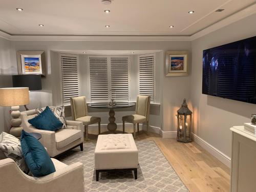 ein Wohnzimmer mit einem Sofa und einem Tisch in der Unterkunft Brand New! Bagpipers Luxury Hideaway at Ard Craig House Glencoe in Glencoe