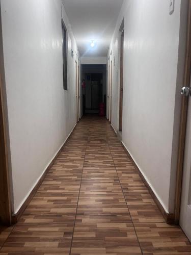 a hallway with a wooden floor and white walls at Las tres cruces in Arica