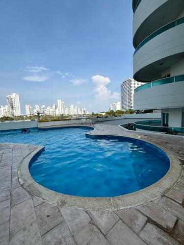 a pool in the middle of a building with a city in the background at Acogedor Apartamento Turístico in Cartagena de Indias
