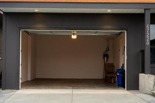 an empty garage with a door open and aphaltphaltphalt at Mountain Retreat with Views, Hot Tub, Games & AC in Chilliwack