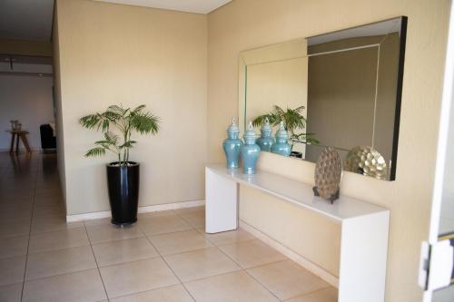 a hallway with a mirror and blue vases at Apartamentos de Temporada Araxá WIFI GRATUITO - ESPAÇO HOME OFFICE in Araxá