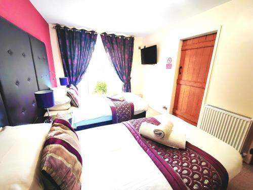 a hotel room with three beds and a window at Dolgun Uchaf Guesthouse and Cottages in Snowdonia in Dolgellau