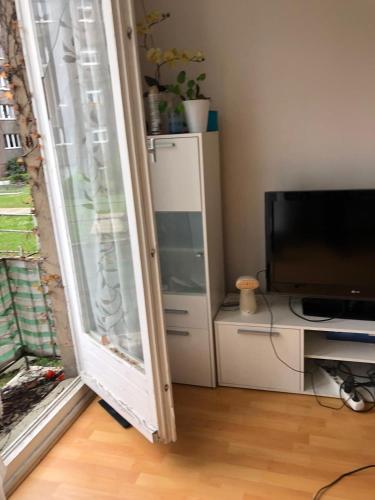 ein Wohnzimmer mit einem Fenster und einem TV in der Unterkunft Cuddle Nest in Berlin