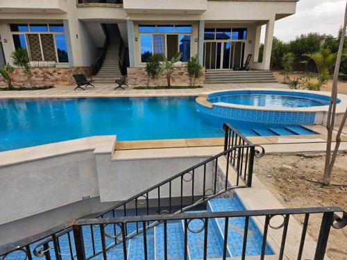 ein Bild eines Hauses mit zwei Swimmingpools in der Unterkunft فندق الفخامة in El-Qaṭṭa