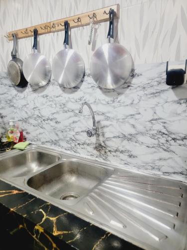 - un comptoir de cuisine avec un évier et quatre ustensiles dans l'établissement Mini Studio tres chic, à Dakar