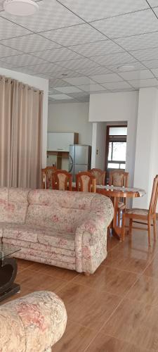 uma sala de estar com um sofá, uma mesa e cadeiras em Santa Ursula Departamento em San Sebastián