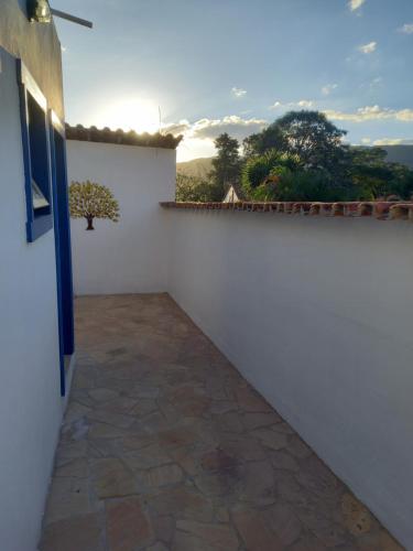 a room with a white wall and a window at Pousada Tabernáculo in Tiradentes