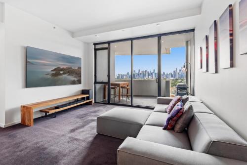 sala de estar con sofá y vistas a la ciudad en 2-Bed, 500m From The Beach with Pool, Gym & Sauna, en Melbourne