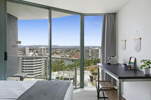 a bedroom with a bed and a desk and glass windows at Studio with Resort Facilities in Prime Location in Gold Coast