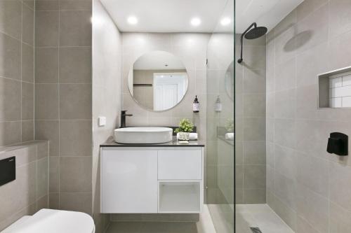 a bathroom with a toilet and a sink and a mirror at Studio with Resort Facilities in Prime Location in Gold Coast
