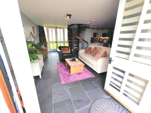 a living room with a couch and a table at Dolgun Uchaf Guesthouse and Cottages in Snowdonia in Dolgellau