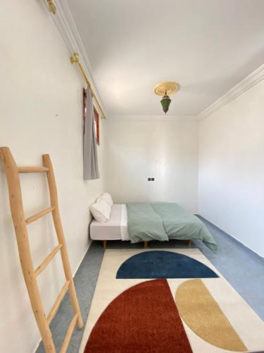 a bedroom with a bed and a ladder and a rug at Surfpoint Tamraght in Tamraght Oufella