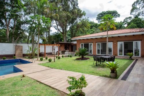 a backyard with a pool and a house at Linda Casa reformada de 4 Suítes no bairro Morumbi - pertinho do Albert Einstein in São Paulo
