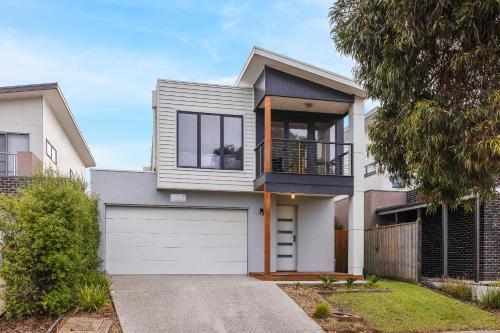 a house with a white garage and a fence at Seagrove Retreat Cowes in Cowes