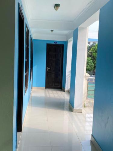 un pasillo con una pared azul y una puerta negra en Khách Sạn Thục Quyên, en Dong Quan