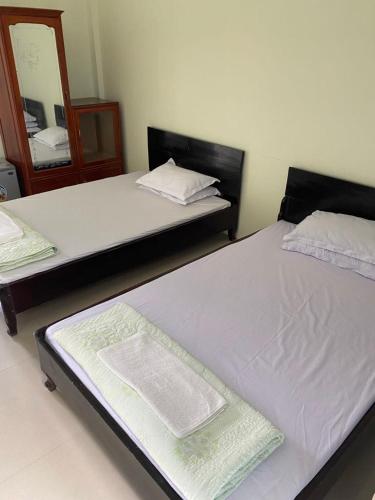2 camas individuales en una habitación con espejo en Khách Sạn Thục Quyên, en Dong Quan