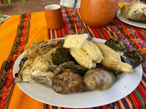 a plate of food with corn and vegetables on a table at Casa acogedora en Mancos, Yungay in Yungay