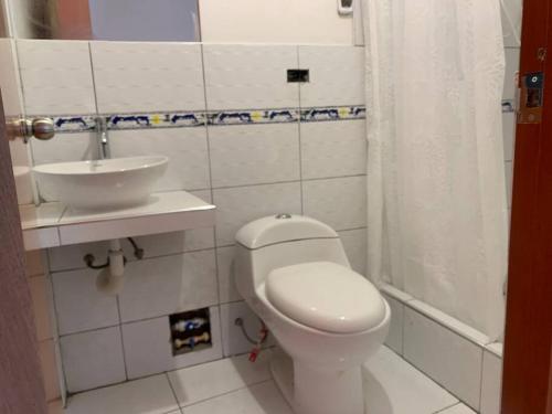 Łazienka z białą toaletą i umywalką w obiekcie Casa acogedora en Mancos, Yungay w mieście Yungay