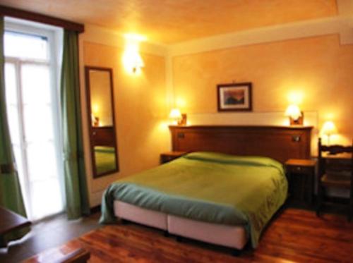 a bedroom with a bed and a large window at Hotel Le Soleil in Challand Saint Anselme