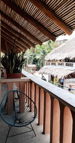 a chair sitting on a balcony next to a table at Casa H Rinconcito Mazunte in Mazunte