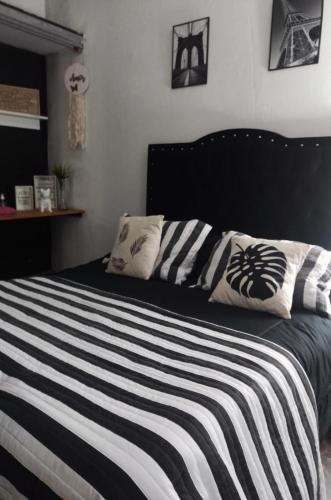 a bedroom with a black and white bed with pillows at La Familia 2 in Ezeiza