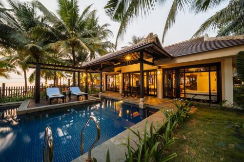 a house with a swimming pool in front of a house at Anja Beach Resort & Spa in Phu Quoc