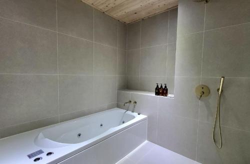a bathroom with a bath tub and a white bath tub at K motel in Geoje