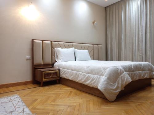 a bedroom with a large bed with a wooden floor at شقق فندقية فاخرة in Cairo