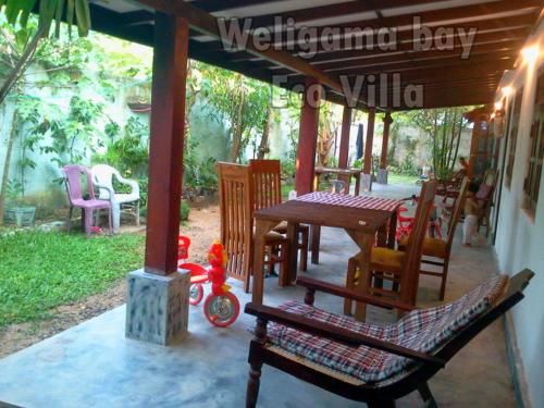 eine Terrasse mit einem Tisch und Stühlen sowie einem Tisch und Stühlen in der Unterkunft Weligama Bay Eco Villa in Weligama