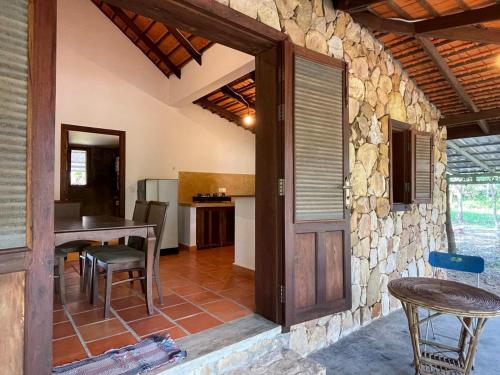 a dining room with a table and a stone wall at Chandara estate kep in Kep