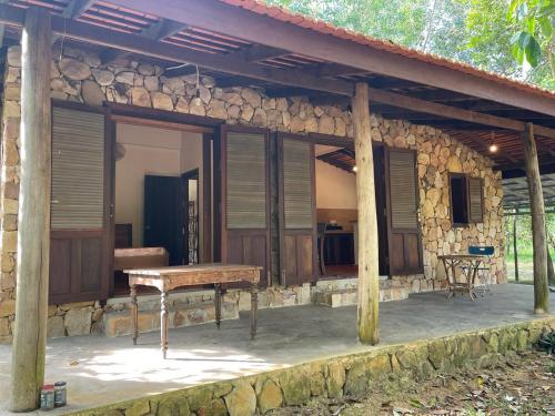 une maison en pierre avec un banc devant elle dans l'établissement Chandara estate kep, à Kep