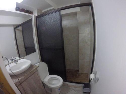 La salle de bains est pourvue de toilettes, d'un lavabo et d'une douche. dans l'établissement Right in the heart of Medellin, à Medellín