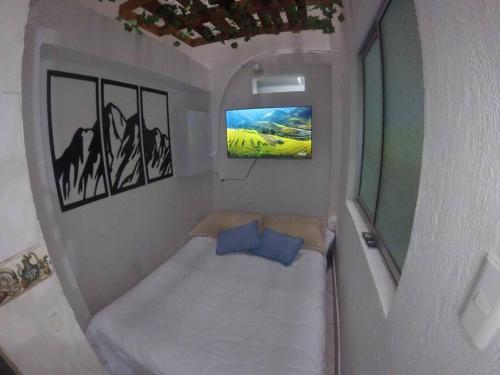 Cette petite chambre comprend un lit et une télévision. dans l'établissement Right in the heart of Medellin, à Medellín