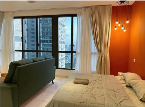 een slaapkamer met een bed en een bank en een groot raam bij Red Sunset Studio Sky 88 JB Town in Johor Bahru