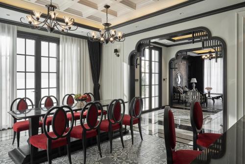 une salle à manger avec une table et des chaises rouges dans l'établissement Villa - Biệt Thự Nghĩ Dưỡng Hạ Long, à Hạ Long