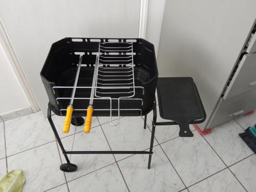 a black chair with two baseball bats on it at Espaço Acolhedor perto da Praia. in São Vicente