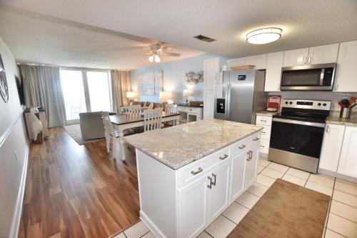 a kitchen with white cabinets and a counter top at 0802 Waters Edge Resort condo in Myrtle Beach